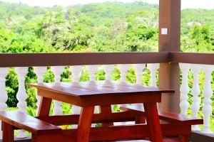 a table and benches on a balcony with a view at Apart Hotel Costa Verde - #2 Exclusivo y Seguro cama King zise in Las Galeras