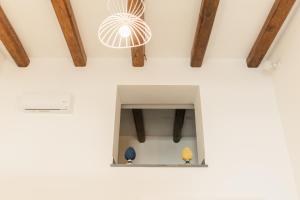 a window in a white wall with wooden beams at Archi Suite Canneto in Canneto