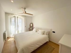 a white bedroom with a bed and a ceiling fan at Casa BlauBegur - ref 056 in Begur