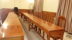 a row of wooden tables in a courtroom at Sokcheav Guesthouse in Sen Monorom