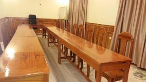 uma fila de mesas de madeira num tribunal em Sokcheav Guesthouse em Sen Monorom