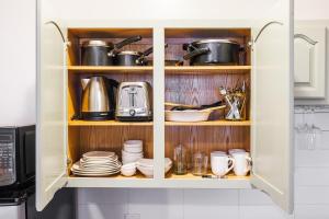 un armario de cocina con platos, ollas y sartenes en Park Side Living, Get Cozy!, en Nueva York