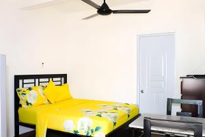 a yellow bed in a room with a ceiling fan at Apart Hotel Costa Verde - #4 Exclusivo con cama Queen in Las Galeras
