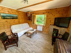 a bedroom with a bed and a tv in a log cabin at Chalet dans la verdure - Les Chapeliers in Uvernet