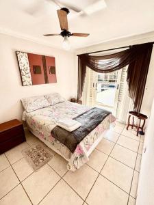 une chambre avec un lit et un ventilateur de plafond dans l'établissement Apartamento Veneza, à Franca