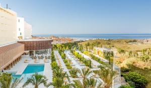 widok z lotu ptaka na ośrodek z basenem i oceanem w obiekcie Higuerón Hotel Curio Collection by Hilton w mieście Fuengirola