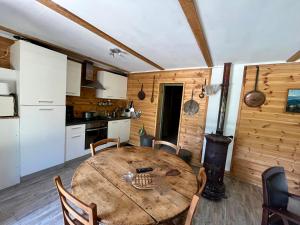 a kitchen and dining room with a wooden table at Chalet dans la verdure - Les Chapeliers in Uvernet
