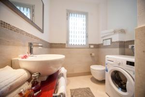 y baño con lavabo y lavadora. en Appartamenti Residence Giardini en Riccione