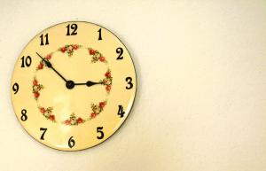 a clock on a wall with a flower wreath on it at Zelený prostorný aparmán v Českém Ráji in Koberovy