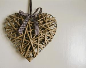 a wicker heart hanging on a wall with a bow at Zelený prostorný aparmán v Českém Ráji in Koberovy +69 photos