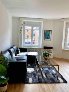 a living room with a black couch and a glass table at KAYA Zurich Apartment SAPPHIRE - Downtown 2BR Deluxe Apt in Zürich