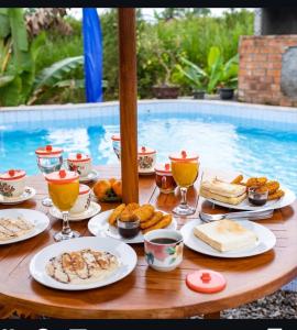 une table avec des assiettes de nourriture à côté d'une piscine dans l'établissement Sandan Agro Resort, à Kintamani