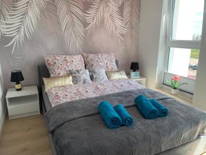 a bedroom with a large bed with blue pillows on it at Apartament Aquapark Gold 8 in Reda +41 photos
