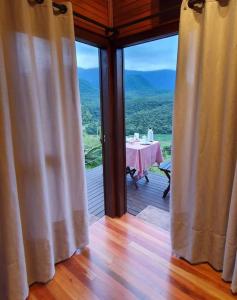 a room with a table and a view of the mountains at Chalé aconchegante com hidro no pé da serra in Orleans +4 photos