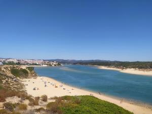 un gruppo di persone su una spiaggia vicino all'acqua di Casa Pereira a Vila Nova de Milfontes
