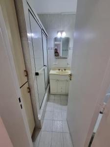 een witte badkamer met een wastafel en een spiegel bij Ruby in Mar del Plata