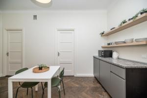 a kitchen with a table and chairs and a counter at Central Avenue Residence Kaunas in Kaunas