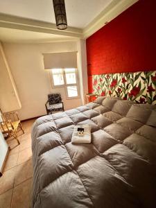 a bedroom with a large bed with a red wall at Hotel Cuesta del Viento in San Juan