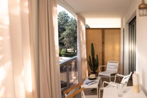 a balcony with a table and chairs and a window at MOB HOTEL Cannes in Cannes