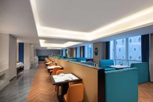 a restaurant with a long line of tables and chairs at Microtel by Wyndham Qingdao Huangdao in Qingdao