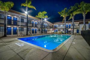 una piscina frente a un edificio con palmeras en Motel 6-Lompoc, CA, en Lompoc
