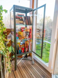 une étagère remplie de nourriture et de livres à côté d'une fenêtre dans l'établissement Domki Drewniane TREBOR, à Międzyzdroje