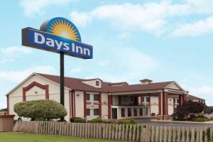 un día de señal de posada delante de una casa en Days Inn by Wyndham Shawnee, en Shawnee
