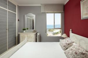 ein Schlafzimmer mit einem weißen Bett und einer roten Wand in der Unterkunft Impresionantes vistas al mar Torrox in Torrox + 15 Fotos