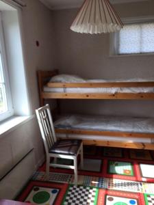 a small room with a bunk bed and a chair at Stora Skedvi in Stora Skedvi