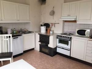 a kitchen with white cabinets and a stove top oven at Stora Skedvi in Stora Skedvi