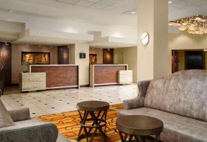 a lobby with a couch and a table and chairs at Sonesta Nashville Airport in Nashville