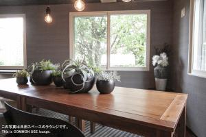 a wooden table with potted plants on top of it at UCHI Living Stay Otaru Suitengu in Otaru