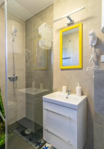 une salle de bain avec un lavabo blanc et une douche dans l'établissement Domki Drewniane TREBOR, à Międzyzdroje 53 autres photos