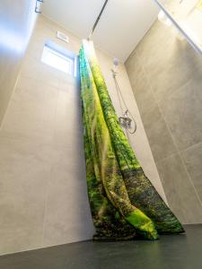 - un rideau de douche dans la cabine de douche de la salle de bains dans l'établissement Domki Drewniane TREBOR, à Międzyzdroje