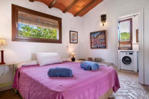 a bedroom with a pink bed with two towels on it at Casa De Los Pintores Facinas in Facinas +24 photos