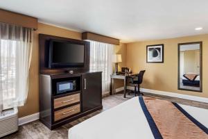 a hotel room with a bed and a flat screen tv at Best Western Plus Newark Airport West in Newark