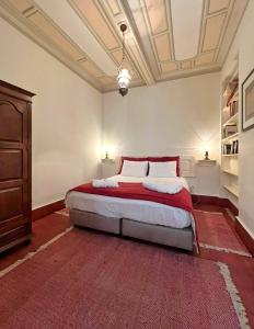a bedroom with a large bed with a red rug at Casa Galricho in Murtosa +50 photos