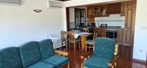 a kitchen with a couch and a table and chairs at Casa da Mila in Rio Caldo