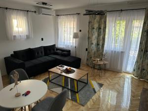 a living room with a black couch and a table at M1-Kraljevo in Kraljevo