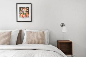 a bedroom with a white bed with a picture on the wall at Beautiful City Center Apartment w Balcony in Aarhus +31 photos