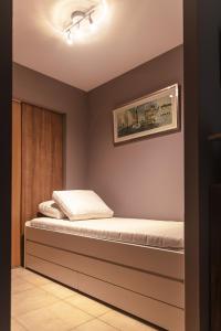 Un dormitorio con una cama con un cuadro en la pared. en Walter R-082, en Koksijde