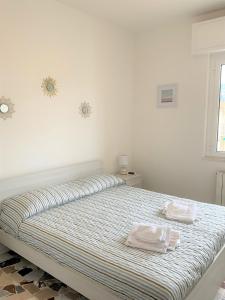 una camera da letto con un letto con due asciugamani sopra di Vista Mare a 150 mt dalla spiaggia - free parking e AC a Pietra Ligure