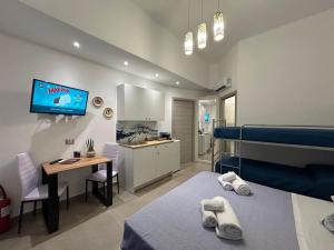 a bedroom with a bed and a desk and a kitchen at CASA DI ANGELA 2.0 in Sciacca