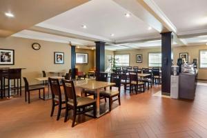 a dining room with tables and chairs and a bar at Best Western Plus Peace River Hotel & Suites in Peace River