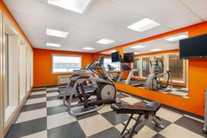 a gym with cardio machines and orange walls at Best Western Plus Peace River Hotel & Suites in Peace River