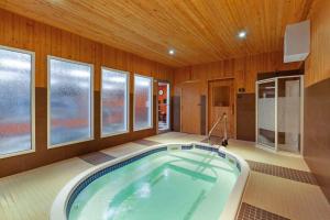 a jacuzzi tub in a room with windows at Best Western Plus Peace River Hotel & Suites in Peace River