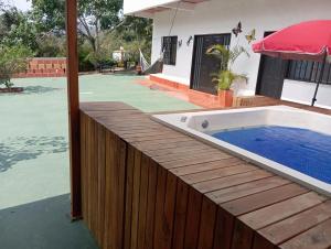 a hot tub on a wooden deck next to a house at Hospedaje Campestre Villa Niny in San Gil