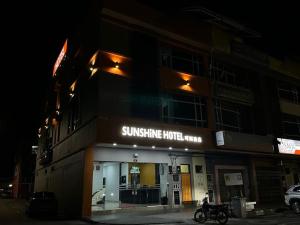 a building with a motorcycle parked in front of it at Sunshine Hotel in Bahau