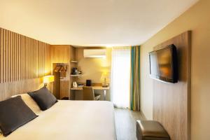 a hotel room with a bed and a television at Best Western Amarys Hotel & Spa in Rambouillet