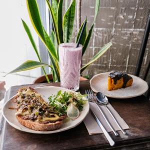 une table avec deux assiettes de nourriture et une boisson dans l'établissement Selina Secret Garden Lisbon, à Lisbonne